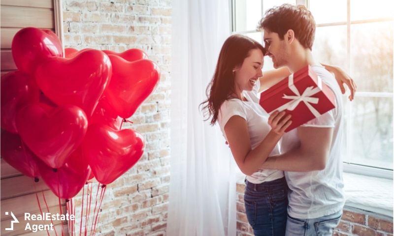 beautiful couple with gift and red balloons