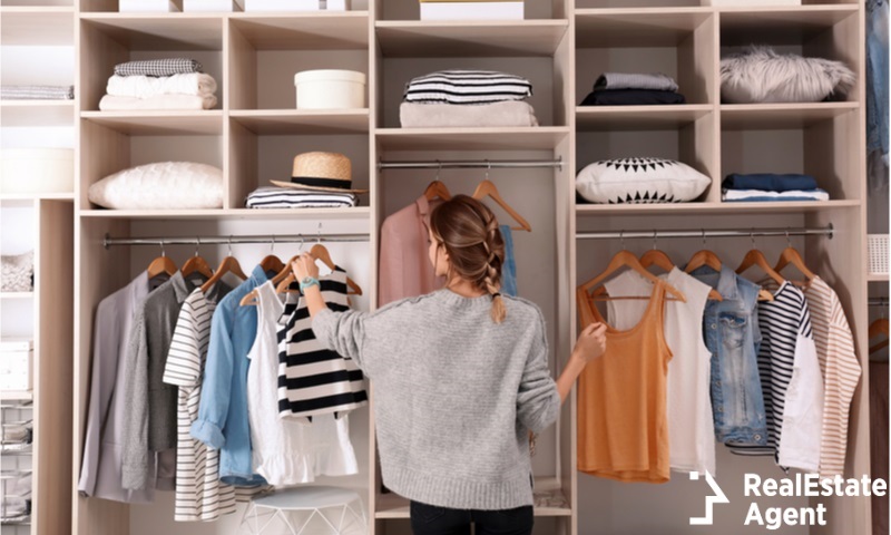 woman choosing outfit from large wardrobe