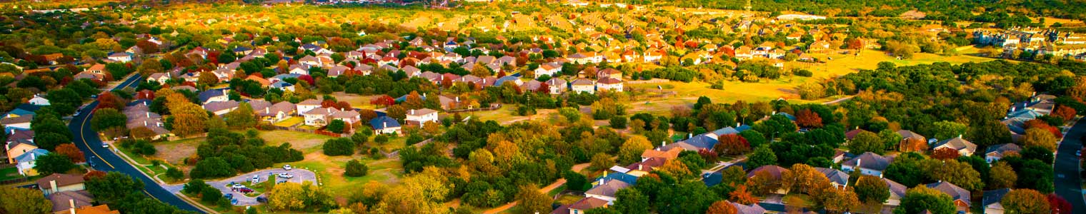 beautiful aerial view of suburbia in central Texas for an expanding housing development with beautiful fall colors and trees