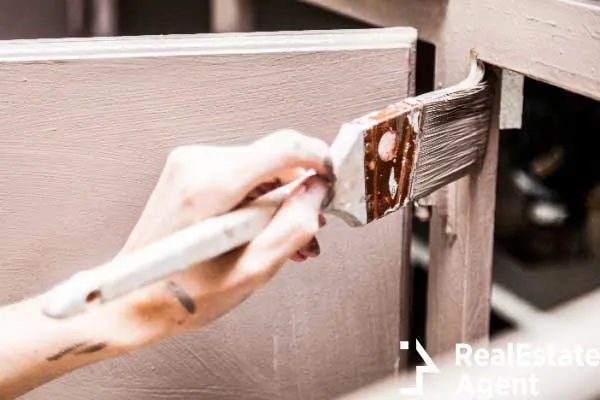 close up person holding paint brush