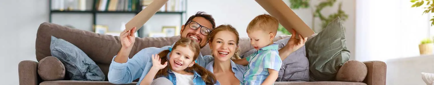 young happy family with 2 kids under cardboard roof