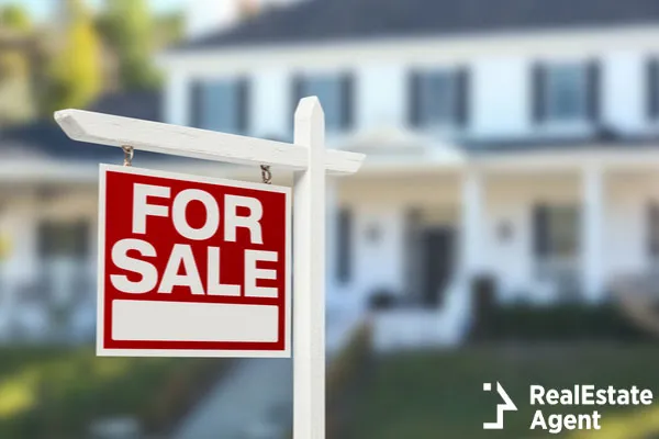 home for sale sign in front of house