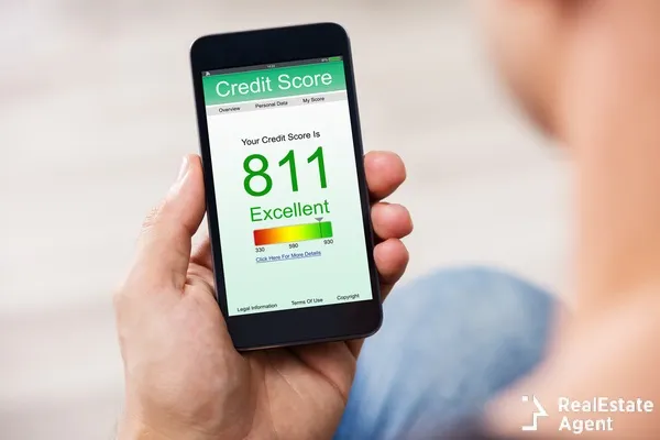man holding a smartphone showing a good credit score