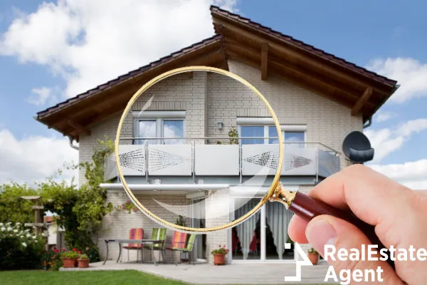 person hand magnifying glass over a luxury house