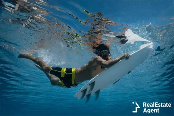 Surfer with surf board dive underwater