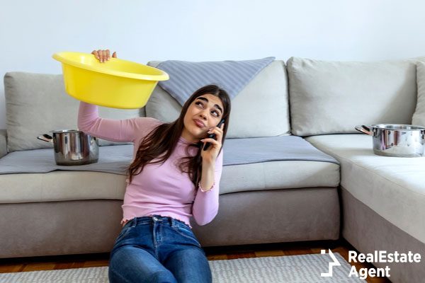 woman looking holding pot under leaking