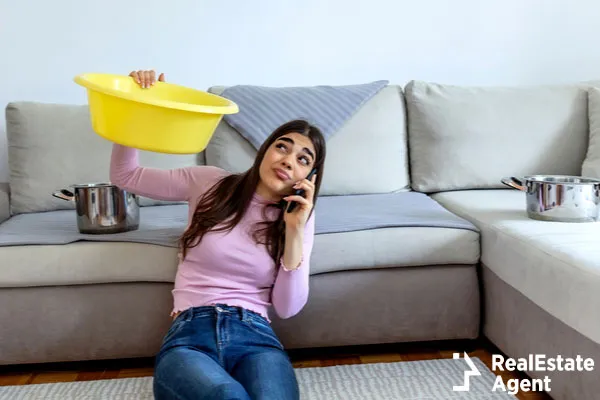 woman looking holding pot under leaking