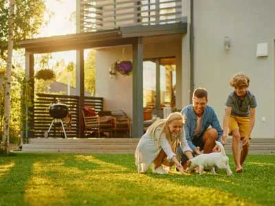 young family with a kid and a puppy in they backyard