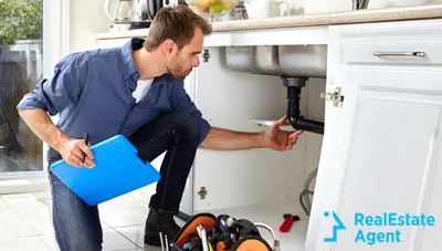 plumber inspecting the kitchen plumbing system