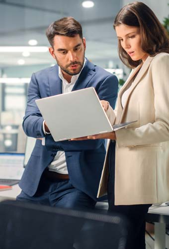 young professional couple looking at laptop young professional couple looking at laptop